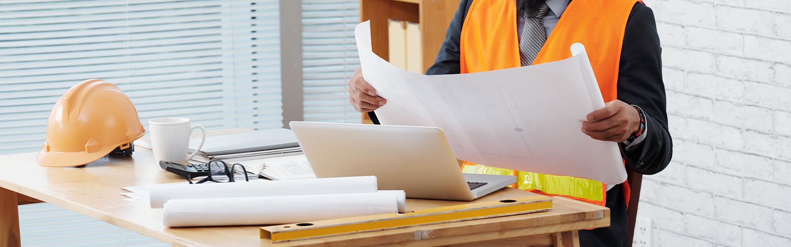 construction contractor holding a blueprint of the area